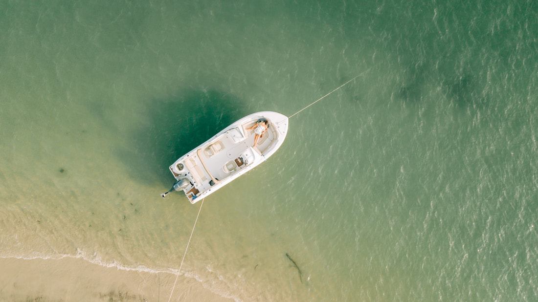Carolina Beach engagement photos by Wilmington Wedding photographer on a boat at a beach with a drone