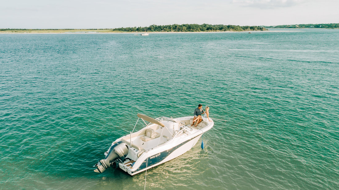 Carolina Beach engagement photos by Wilmington Wedding photographer on a boat at a beach with a drone