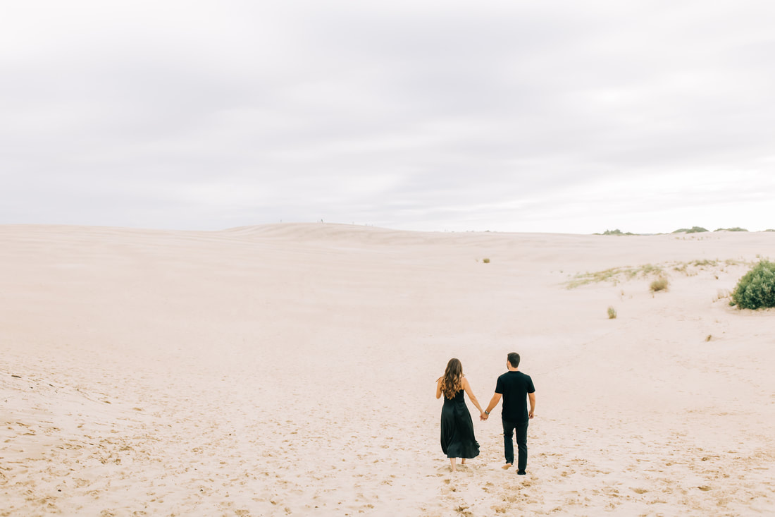 Jockey's ridge sand dune engagement in all black outfits