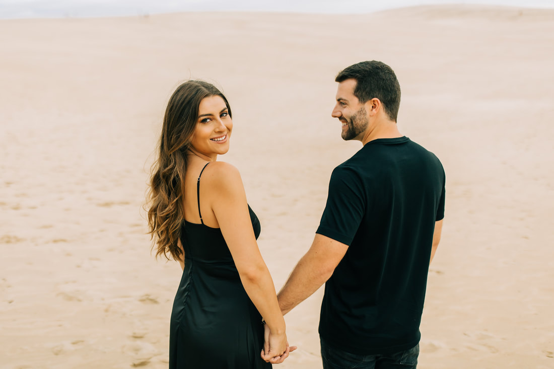 Jockey's ridge sand dune engagement in all black outfits